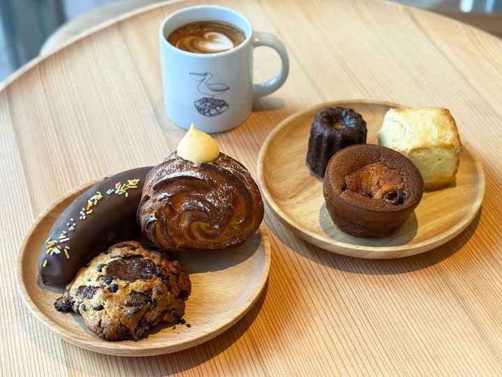 カフェラテ000円 （左のお皿、上から時計まわり）カヌレ313円、スコーン237円、ファーブルトン378円（右のお皿、上から時計まわり）バナナのチョコレート生フィナンシェ831円、シュークルーラー（カスタード）496円、チョコレートジャンキークッキー410円