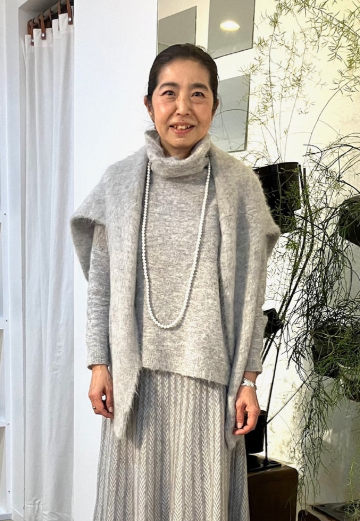 「グレーのワントーンスタイルでまとめました」と三好さん。「ワントーンコーデは、すっきり見せしてくれるので、バランスがまとまりやすいのですが、単調になってしまう場合もあるので、柄物スカートやニットカーディガンなどをアクセントに」。肩掛けしたニットとスカートは、ル シェル ド ハリス。同系色のオフタートルニットはベラ ジョーンズのもの。ハリスのパールロングネックレスをオン。