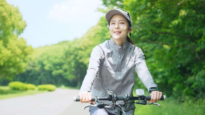 公園で自転車に乗る笑顔の女性 