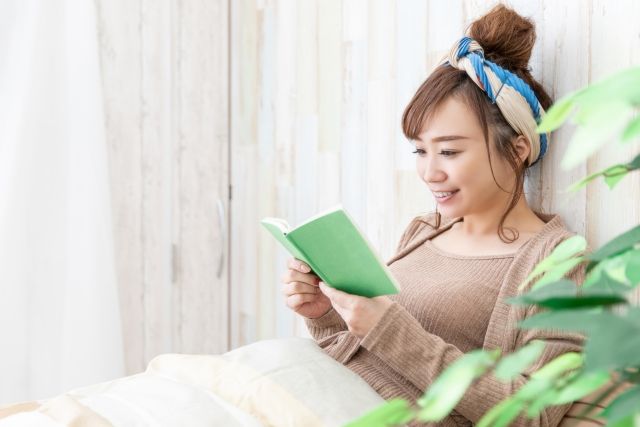 ノートを笑顔で眺める女性