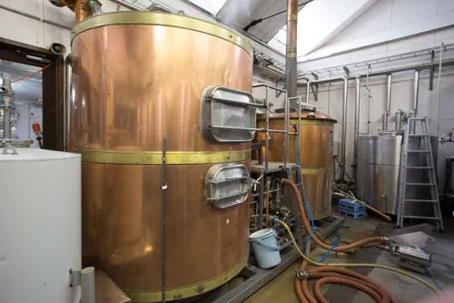銅製タンクとステンレスタンクが並ぶ醸造設備