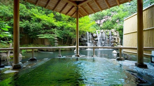 【写真】庭園の緑と滝を望む露天風呂「聴瀧の湯」。池に浮かぶような造りが特徴
