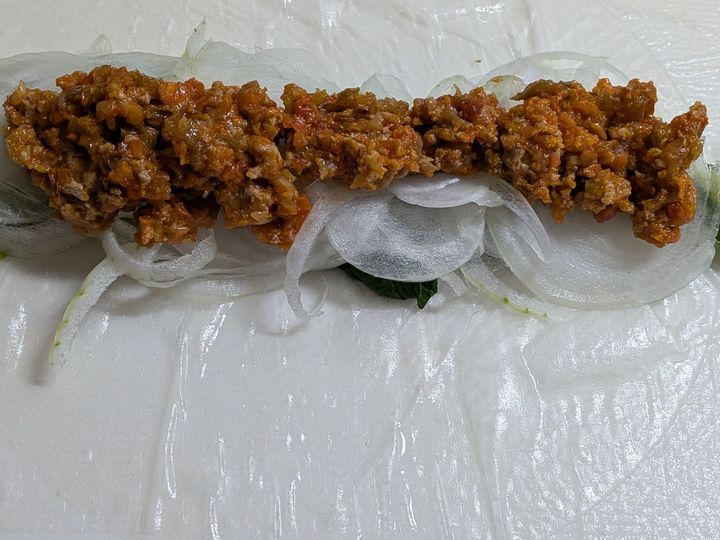 3.ライスペーパーを水に濡らし、菜の花、新たまねぎ、ミートソースの順にのせ、手前から巻く