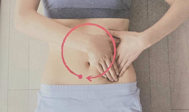 お腹を手で押さえる