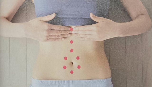 みぞおちを手でマッサージ