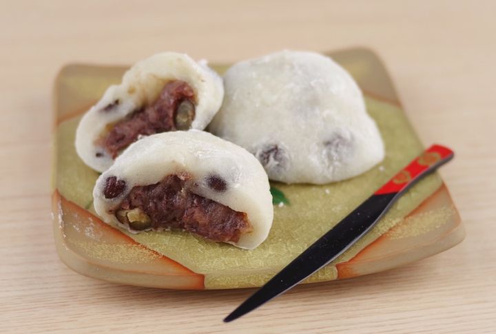 お皿に盛られた半分でカットした豆大福と丸ごとの豆大福