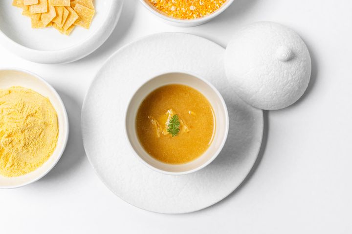 【AMUSE(アミューズ) - 継承 -】<br /> 愛媛県産の媛っこ地鶏を使ったコンソメに、「地とうきび(トウモロコシ)」の粉末「はなこ」の旨味を重ねたスープに、ひきわりの「地とうきび」から仕立てた自家製パスタを合わせている。