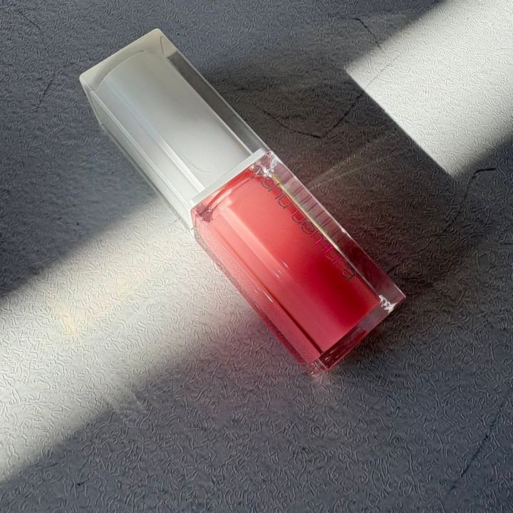 シュウ ウエムラのリップオイル「キヌケアCCオイル ピンクアイシング」。スキンケア発想で唇をケアしながら、自然なツヤをプラスしてくれる万能ピンクカラー。