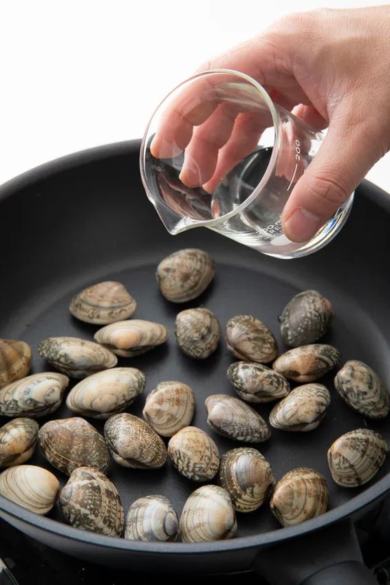 フライパンにあさりを入れ、酒、しょうがを入れる