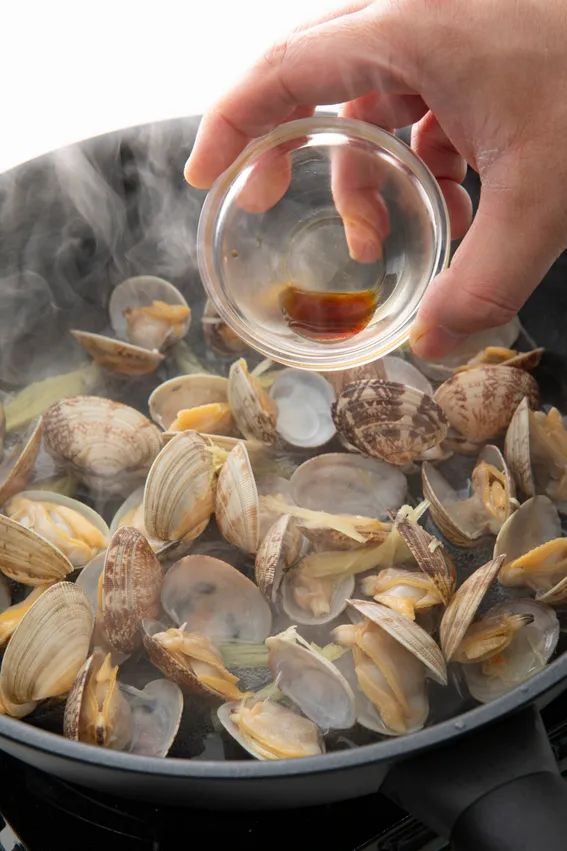 あさりの口が開いたら火を止めしょうゆ、三つ葉を入れる