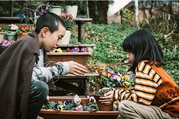 名無し”と幼い頃から行動を共にする花子 [c]佐藤二朗 永田諒 ／ ヒーローズ [c]2026 映画「名無し」製作委員会