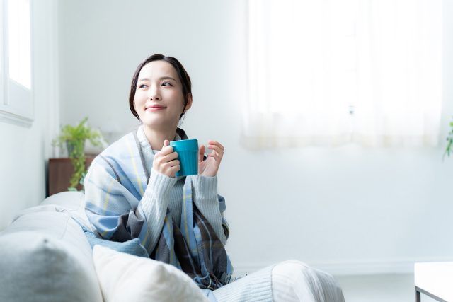 朝、あたたかいものを飲む女性