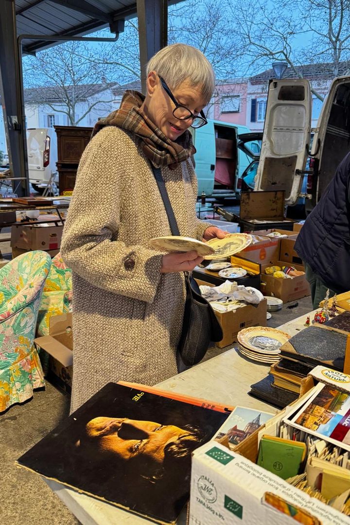 買い付けは、遠方の蚤の市まで遠征することも。「じっくりと良い品物を探して回るときは、やはり体力勝負です」19世紀後半のクレイユ エ モントローのお皿を吟味中。