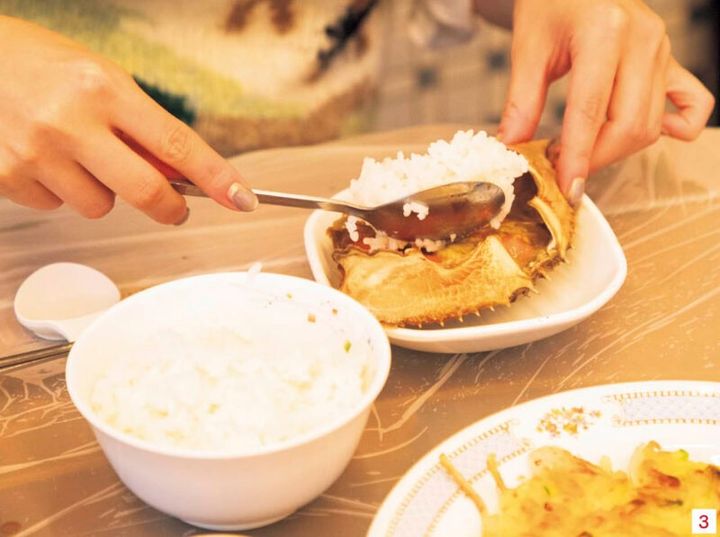 3.食べ進めたら味変もぜひ。甲羅のみそをかき集めたら白米をのせて、エゴマのすりごまとエゴマ油をかけたらかき混ぜて、のり巻きにして食べてみて。