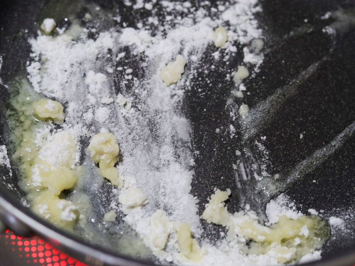 フライパンに溶けたバターと薄力粉を振り入れて炒めている様子