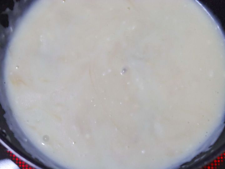 フライパンでとろみがついた白いクリームソースが煮立っている様子