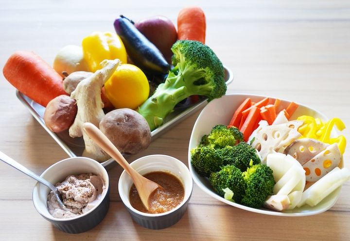 蒸し野菜と生野菜とディップソース2種が机に並んでいる様子