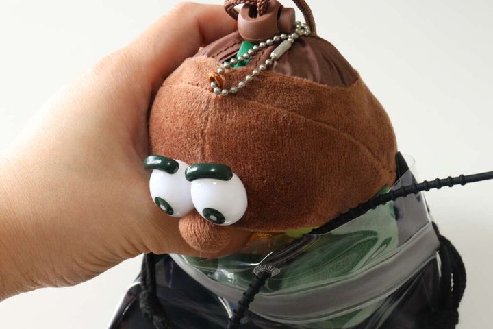 セリアのぬいぐるみ巾着バッグに人形を収納する様子