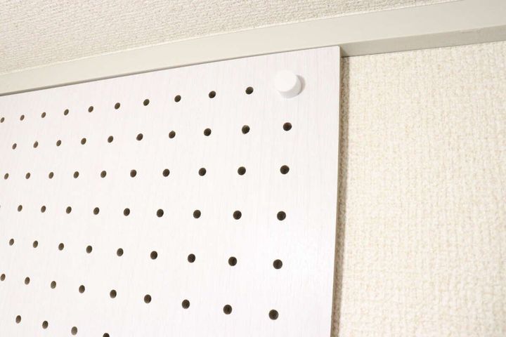 ダイソーの壁面に取り付けできるネジ型ピンで有孔ボードを設置した様子