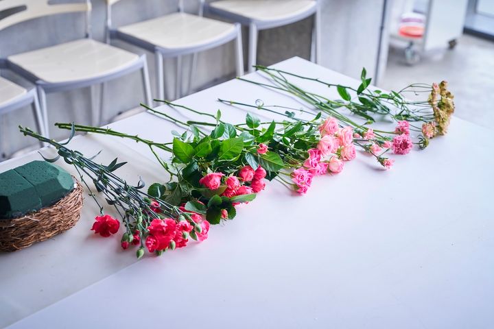 花材は左から、スプレーカーネーション（ホットピンク）、スプレーバラ（カンタービレ）、スプレーバラ（ストロベリーポロン）、スプレーバラ（ピンクワルツ）、スプレーカーネーション（ミニティアラピンク）、スカビオサ（サーモンQ）、スプレーバラ（コンフェイト）