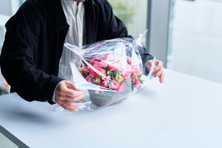 完成したアレンジメントをラッピングする西垣さんの手元