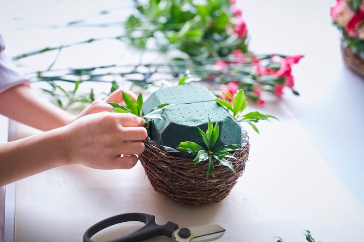 グリーンをオアシスに挿している中條さんの手元