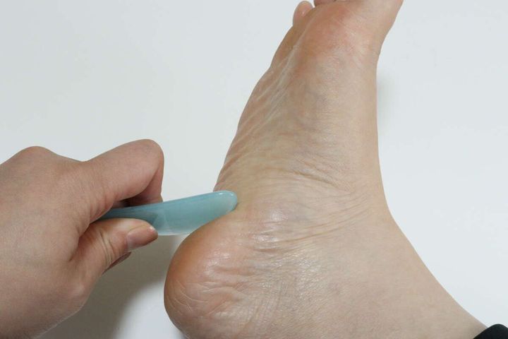 ダイソーのかっさプレートで足裏をマッサージする様子