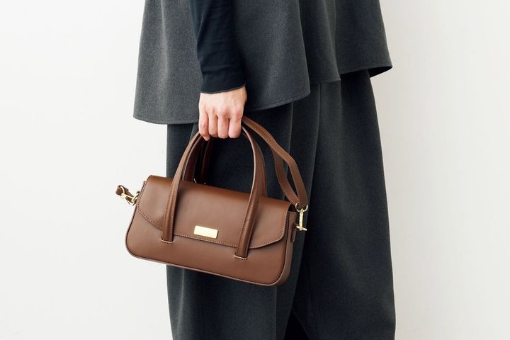 オウレンティのブラウンのレザーバッグで装いに軽さを。