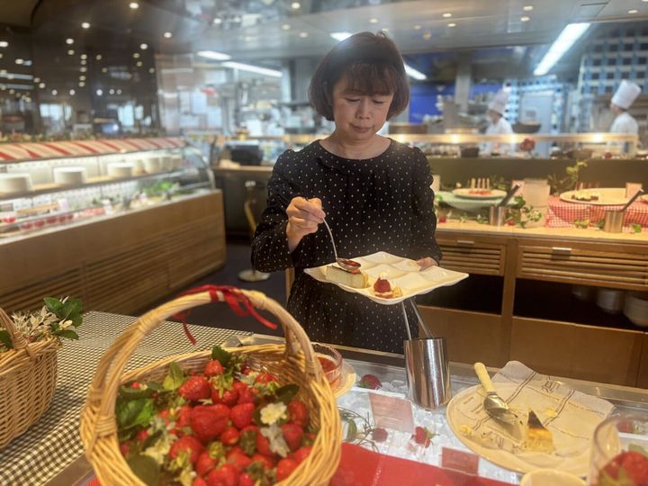 神戸ポートピアホテルのいちごスイーツブッフェ「ストロベリー・ピクニック」のバスクチーズケーキにソースをかけている様子