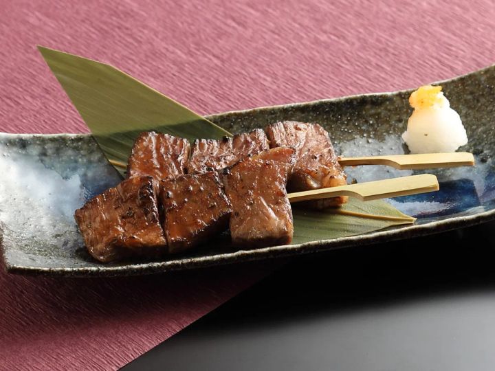 笹の葉を敷いた皿に近江牛の串焼き2本とおろしポン酢を添えた一