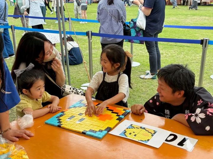 廃プラタイルでアヒルのピクセルアートを完成させた親子の笑顔