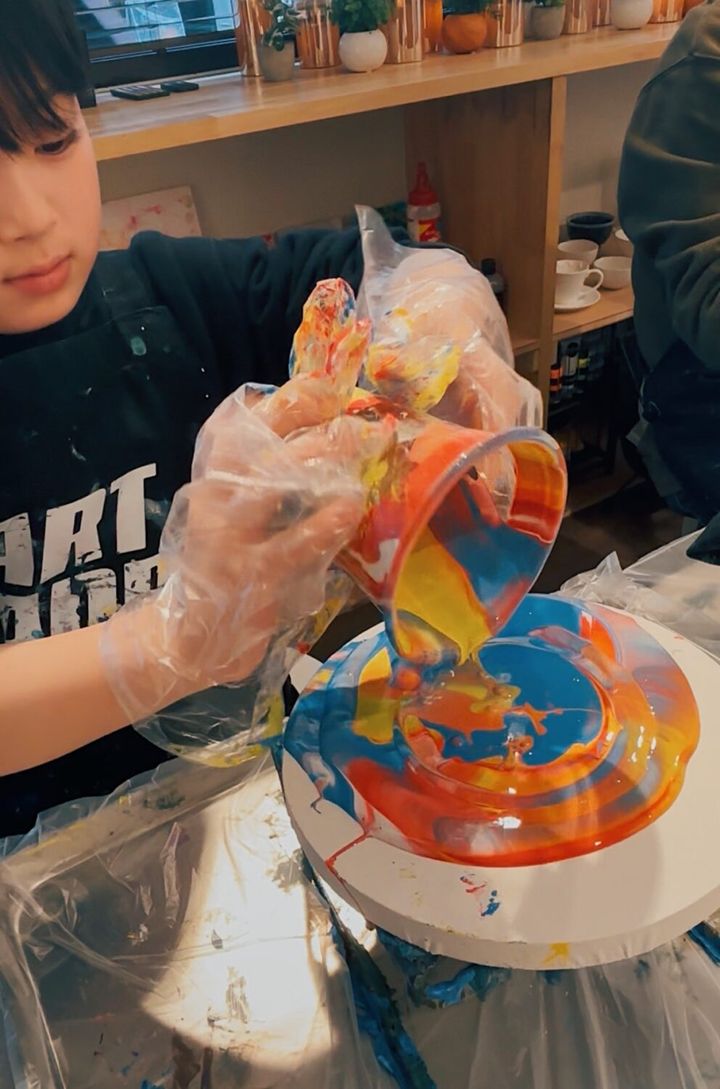 【手ぶらOK！】子どもが夢中！気軽に楽しめる『たらし込みアート』体験レポ。キャンバスに絵の具を垂らす作業。コップを離すと美しいマーブル模様がでてくる。