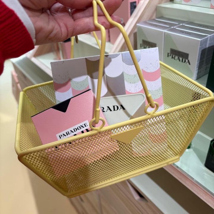 プラダ ビューティの期間限定イベント「プラダ ビューティ マーケット」の会場で、パステルカラーのコスメが入った黄色いミニバスケットを持つ様子