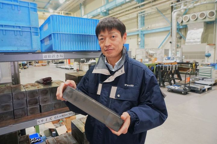 削る前の10キロの塊を持つ石川さん。ここから270グラムまで削る