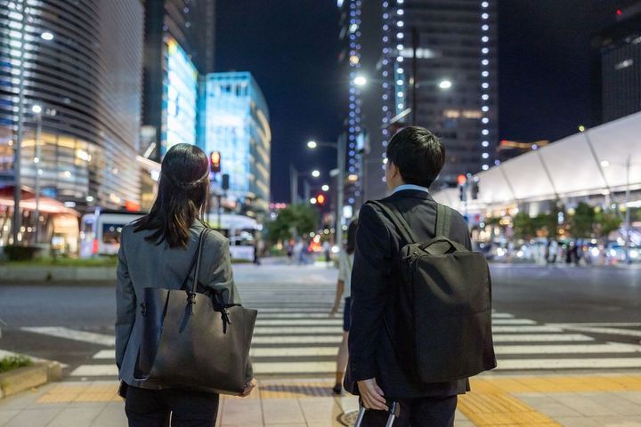 夜の街のビジネスマンの後ろ姿