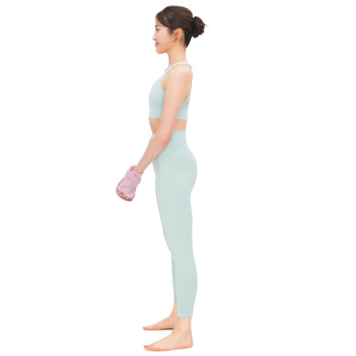 1. 足を肩幅に開いて立ち、タオルを両手首に巻きつけて固定。