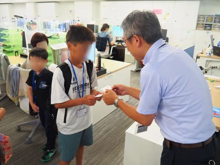 こども参観日で職場見学・名刺交換体験を行う様子