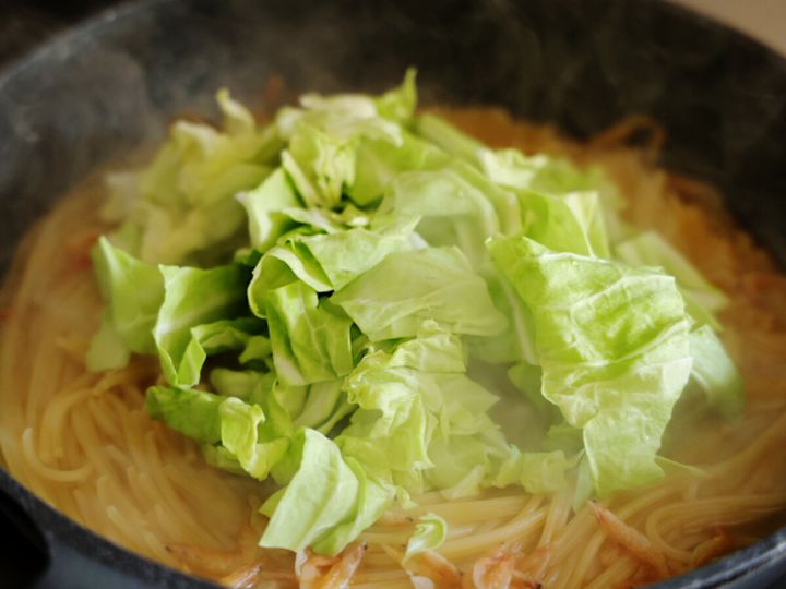 茹でているスパゲッティが入ったフライパンにざく切り春キャベツを加えている工程写真