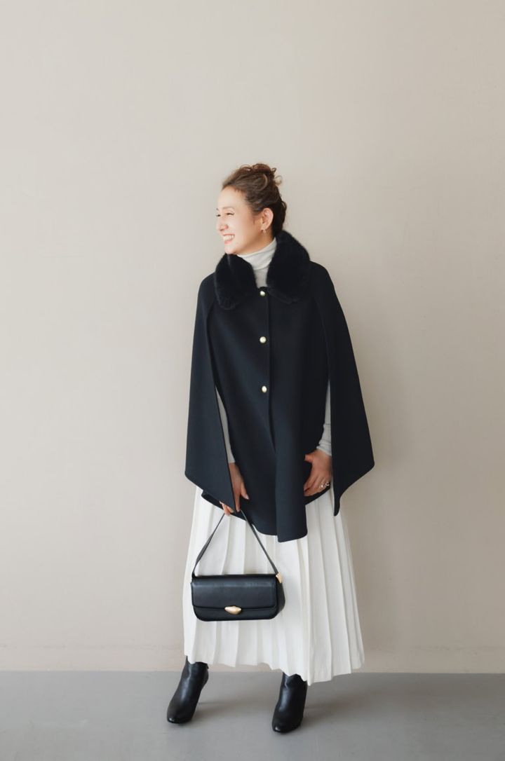 マント¥187,000／エルマンノ フェレンツェ、ニット¥132,000、スカート¥170,500／ともにジェントリー ポルトフィーノ（すべてウールン商会）、ピアス¥233,200 、リング（薬指）¥176,000、リング（小指）¥299,200／すべてプライマル、バッグ¥59,400 ／マエストソ（アマン）、シューズ¥97,900／ペリーコ（アマン）