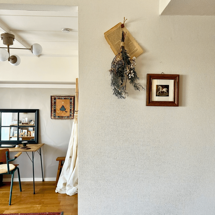 手前：小さな絵とドライフラワー、後ろの部屋：小さなラグを壁掛けにした写真