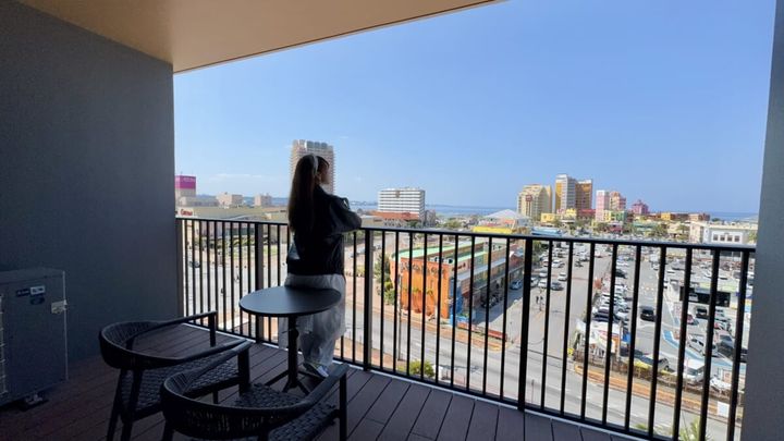 「リーガロイヤルリゾート沖縄 北谷」女性が部屋のベランダに出て外を眺めている様子