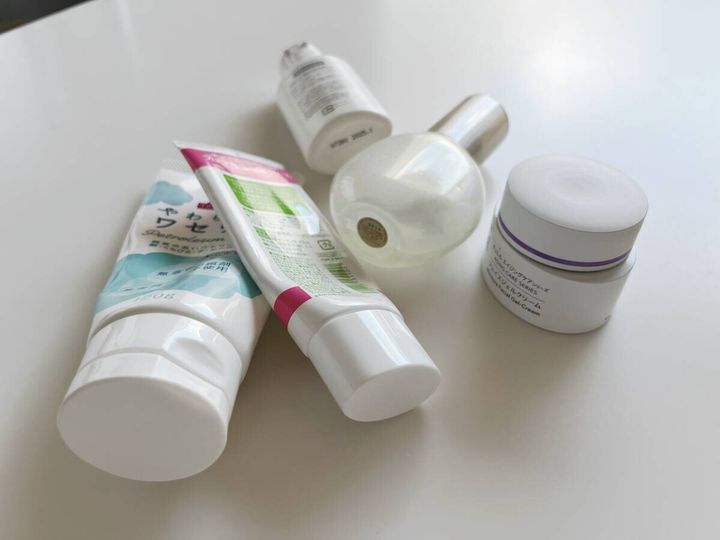 白いテーブルの上に複数のスキンケア用品が散らばっている様子