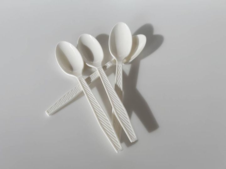 白い使い捨てプラスチックスプーン3本が重なって置かれた俯瞰写真