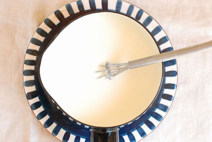 小鍋に泡立て器でゼラチン液を加えよく混ぜている俯瞰写真