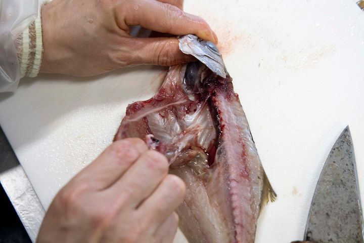 手と包丁で身を押し開く