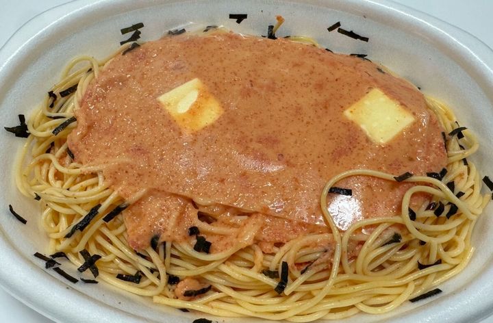 容器の淵ギリギリまで盛り付けられたパスタの山の上にはたっぷりの明太子ソースとバターがトッピング