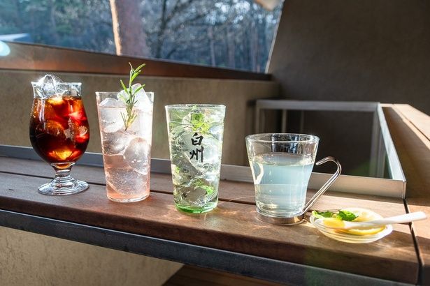 「Hakushu Terrace」では、シーズナルメニューの「白州お湯割りートディスタイルー」(800円)を楽しんで(写真右)。そのほかにも、「白州 森香るハイボール」(700円)、「ラズベリーハイボール」(1200円)、「サントリー天然水〈南アルプス〉仕込み 水出しアイスコーヒー」 (500円)がおすすめ！(写真右2番目から)
