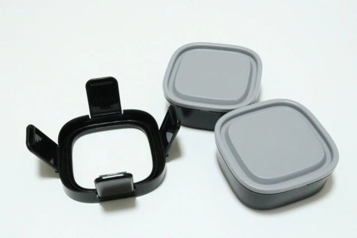 黒いロックフレームと灰色蓋付き容器2つに分解されたランチボックスのパーツ一式