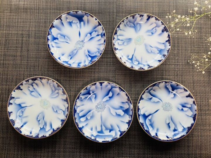 グレーの布の上に並べられた青白の花柄陶器の豆皿5枚を俯瞰で撮影した様子