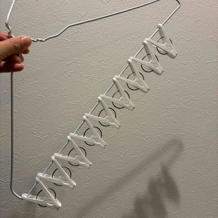 洗濯バサミをハンガーに通しているところ